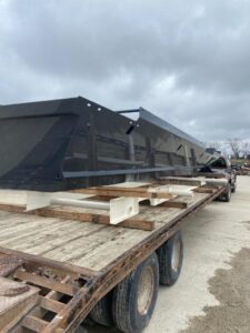 Side view picture of metal parts on a flatbed truck